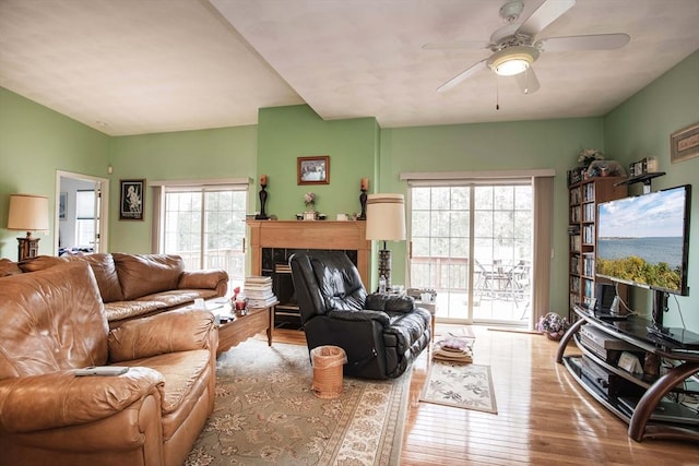 living area featuring hardwood / wood-style flooring, a fireplace, and a ceiling fan