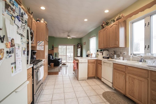 kitchen featuring light tile patterned floors, decorative backsplash, appliances with stainless steel finishes, a peninsula, and light countertops