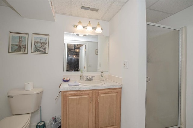 full bathroom featuring a stall shower, visible vents, toilet, and a drop ceiling