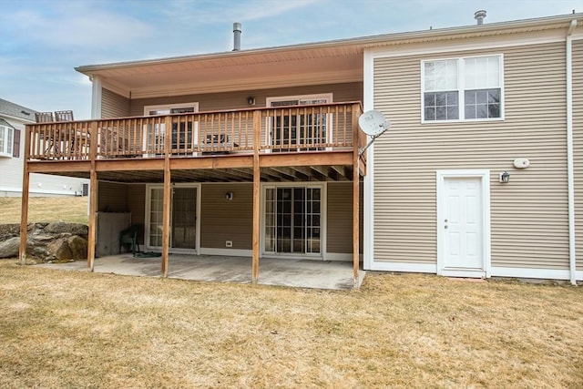 rear view of house with a patio, a lawn, and a wooden deck