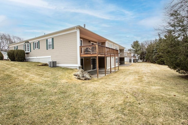 view of home's exterior featuring a lawn, a wooden deck, and central air condition unit