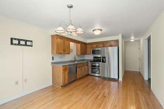 5 Saint John Ln Unit 5, Milford, MA 01757 - kitchen with stainless steel appliances, a chandelier, light wood-style flooring, decorative light fixtures, and brown cabinets