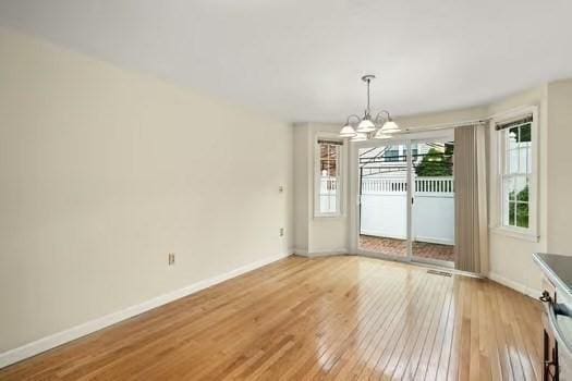 5 Saint John Ln Unit 5, Milford, MA 01757 - unfurnished dining area featuring light wood-style floors and a chandelier