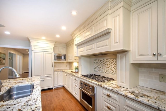 265 King St, Cohasset, MA 02025 - kitchen with built in appliances, backsplash, light wood-style floors, recessed lighting, and light stone countertops