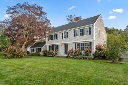 colonial inspired home featuring a front lawn