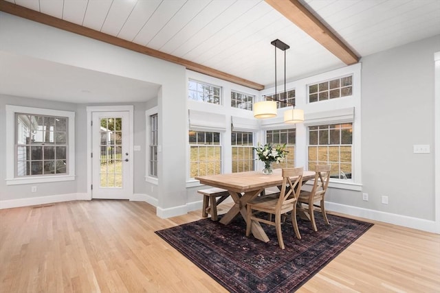 dining room featuring beamed ceiling, wood ceiling, and light hardwood / wood-style floors