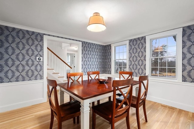 dining area with crown molding and light hardwood / wood-style floors