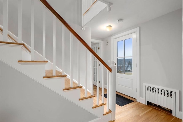 stairway featuring radiator and hardwood / wood-style floors