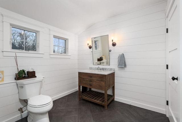 bathroom featuring lofted ceiling, toilet, and vanity