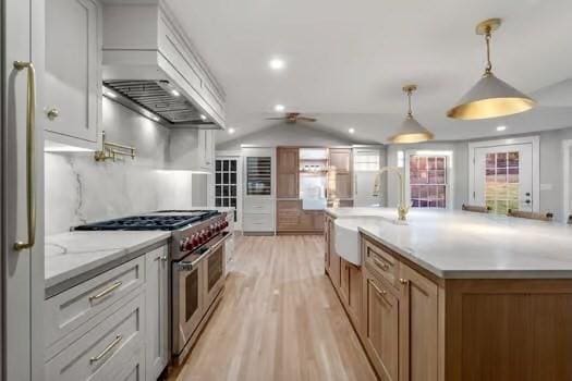 kitchen with a spacious island, double oven range, hanging light fixtures, and white cabinets