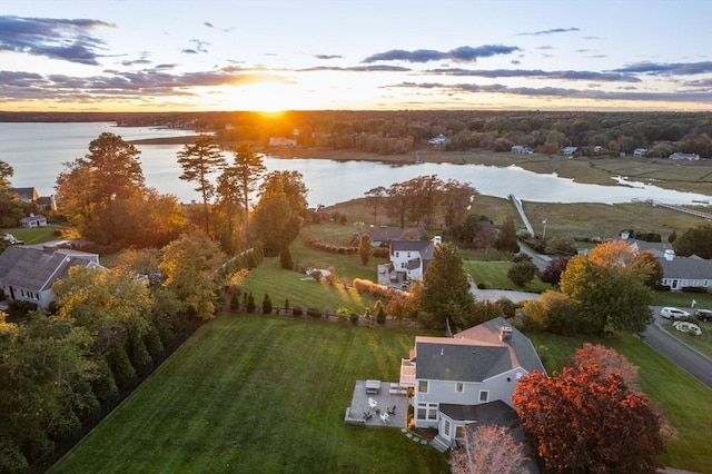 aerial view at dusk featuring a water view