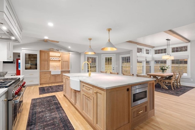 kitchen featuring a spacious island, stainless steel appliances, decorative light fixtures, and premium range hood