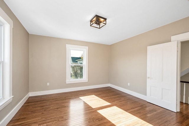 11-13 Read St, Lowell, MA 01850 - unfurnished bedroom with multiple windows, wood-type flooring, and baseboards