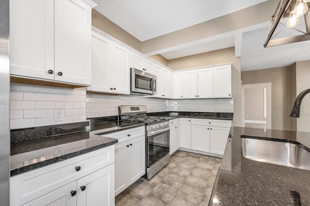 11-13 Read St, Lowell, MA 01850 - kitchen featuring stainless steel appliances, a sink, white cabinetry, tasteful backsplash, and dark stone counters