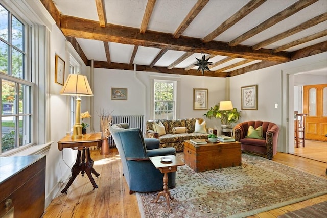 1395 Canton Ave, Milton, MA 02186 - living room with beamed ceiling, light wood finished floors, radiator, and ceiling fan