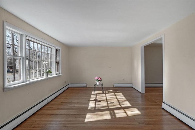 spare room featuring a baseboard radiator and wood finished floors