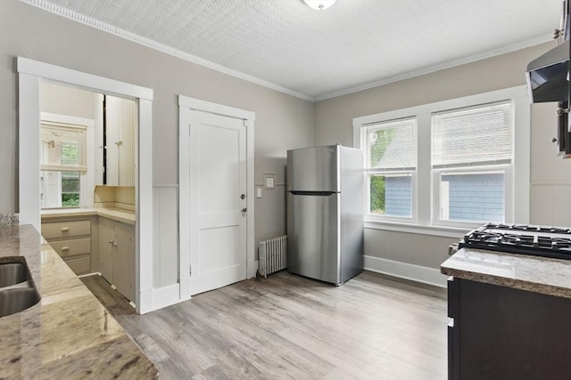 31-33 Beauchamp St, Springfield, MA 01107 - kitchen with freestanding refrigerator, radiator heating unit, ornamental molding, plenty of natural light, and light wood-type flooring