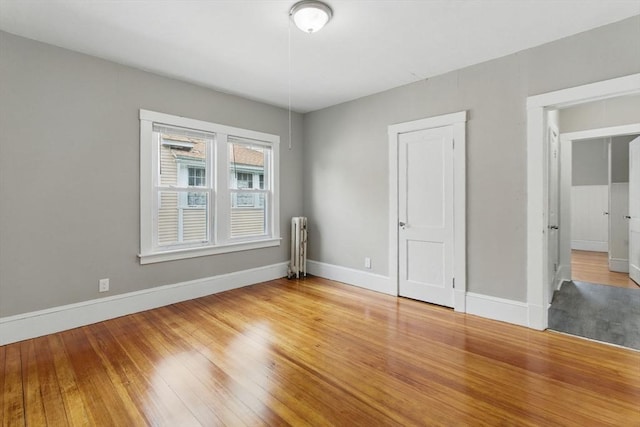 31-33 Beauchamp St, Springfield, MA 01107 - unfurnished bedroom with baseboards, radiator heating unit, and light wood-style floors