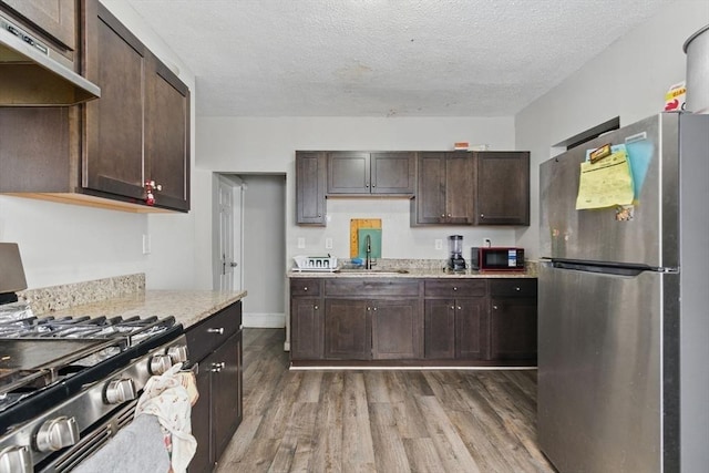 31-33 Beauchamp St, Springfield, MA 01107 - kitchen featuring appliances with stainless steel finishes, under cabinet range hood, a sink, wood finished floors, and dark brown cabinets