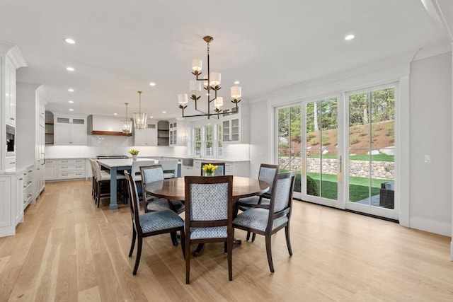 dining area featuring recessed lighting, ornamental molding, light wood finished floors, and a chandelier