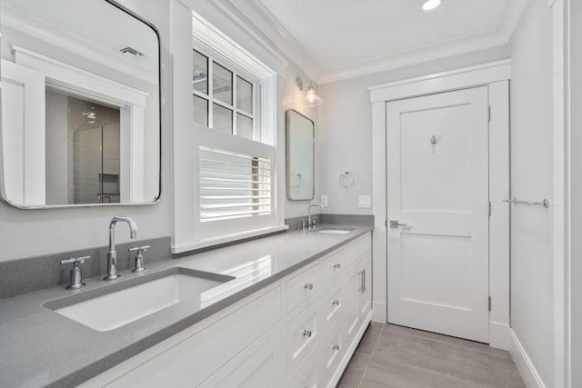 bathroom featuring crown molding, double vanity, visible vents, and a sink