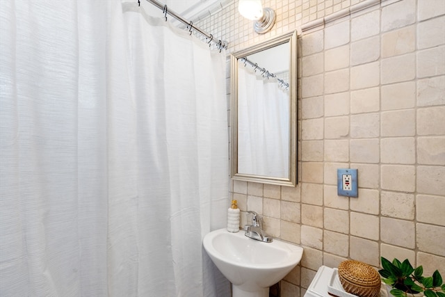 bathroom with sink and tile walls