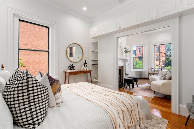 bedroom featuring ornamental molding, hardwood / wood-style flooring, and radiator