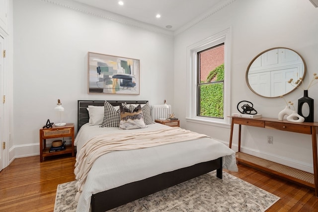 bedroom featuring ornamental molding and dark hardwood / wood-style flooring