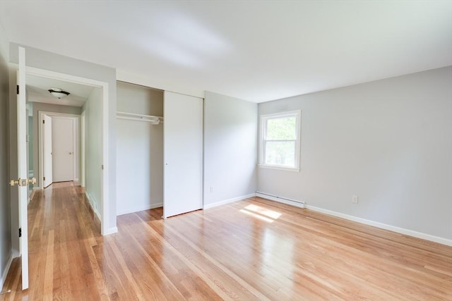 24 Harwich Rd, East Longmeadow, MA 01028 - unfurnished bedroom featuring baseboard heating, light wood-style floors, a closet, and baseboards