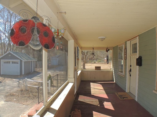 view of patio / terrace with a porch, an outbuilding, and a detached garage