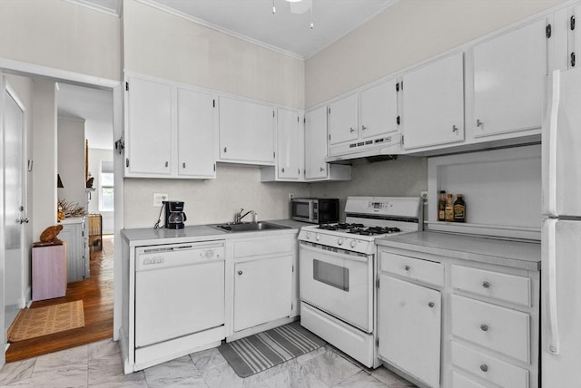 kitchen featuring white appliances, under cabinet range hood, a sink, light marble finish floors, and white cabinets