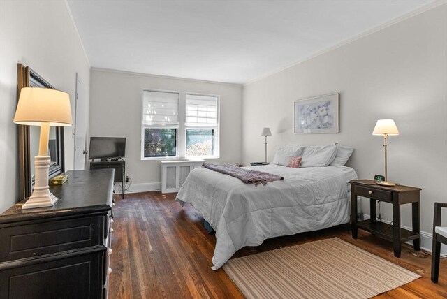 bedroom featuring radiator, dark wood-type flooring, baseboards, and ornamental molding