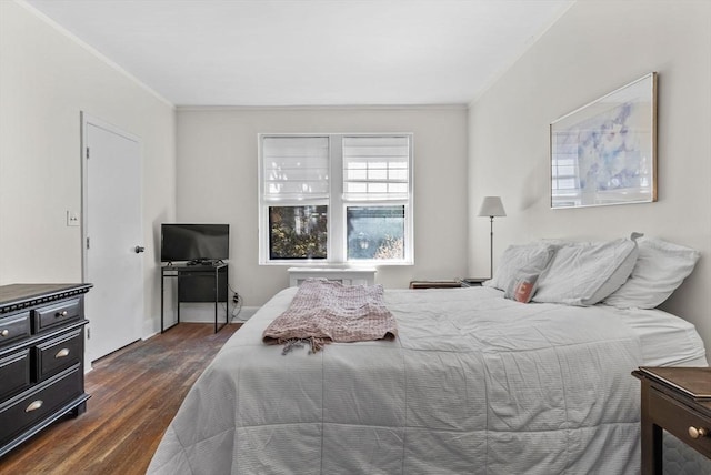 bedroom with dark wood-style flooring and ornamental molding