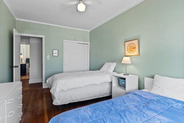 bedroom with hardwood / wood-style flooring, crown molding, baseboards, a ceiling fan, and a closet