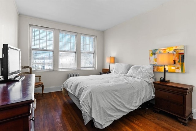 bedroom with hardwood / wood-style floors, baseboards, and radiator
