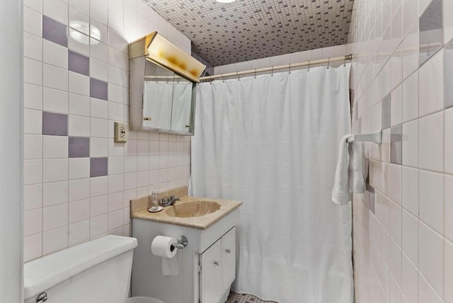 bathroom with tile walls, toilet, a shower with shower curtain, and vanity
