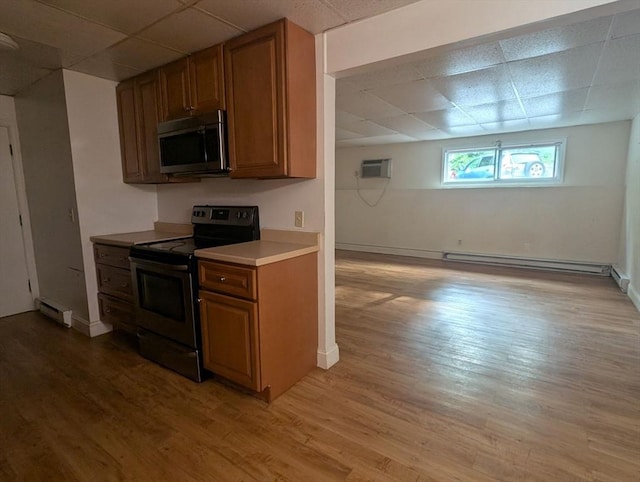 300 Smithfield Rd Unit 2-2, North Providence, RI 02904 - kitchen with stainless steel appliances, a paneled ceiling, baseboard heating, a baseboard radiator, and brown cabinets
