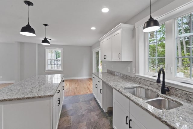 21 Stephanie St Unit 1, Gardner, MA 01440 - kitchen featuring a sink, a kitchen island, baseboards, recessed lighting, and white cabinetry