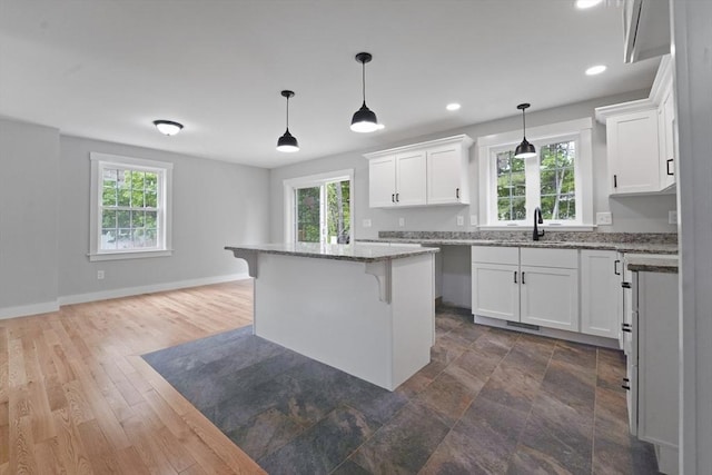 21 Stephanie St Unit 1, Gardner, MA 01440 - kitchen featuring plenty of natural light, white cabinetry, a breakfast bar area, light stone counters, and recessed lighting