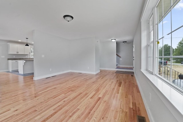 21 Stephanie St Unit 1, Gardner, MA 01440 - unfurnished living room featuring light wood-type flooring, baseboards, and stairway
