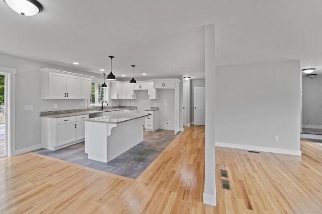 21 Stephanie St Unit 1, Gardner, MA 01440 - kitchen with healthy amount of natural light, a sink, recessed lighting, light wood-style flooring, and white cabinets
