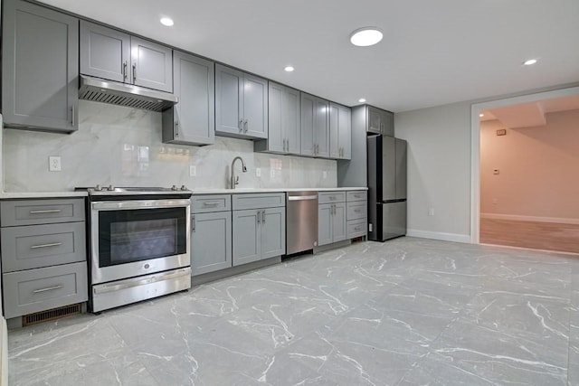 kitchen with stainless steel appliances, gray cabinets, and under cabinet range hood