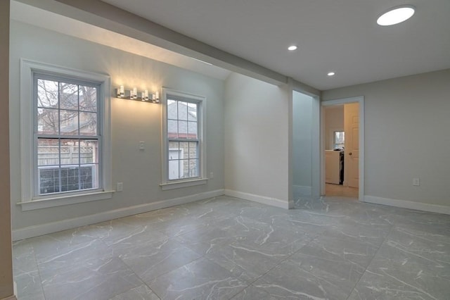 unfurnished room featuring baseboards, a wealth of natural light, recessed lighting, and marble finish floor