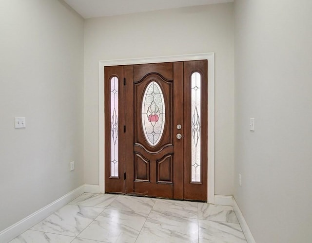foyer entrance featuring baseboards and marble finish floor