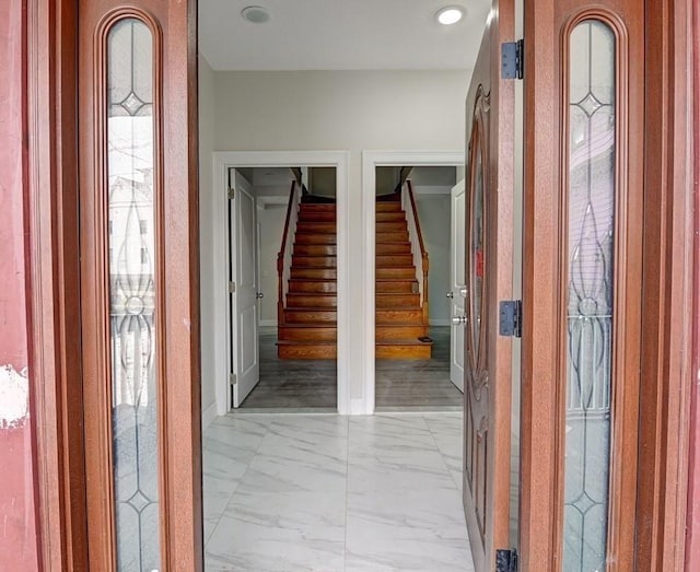 hallway featuring stairway and marble finish floor