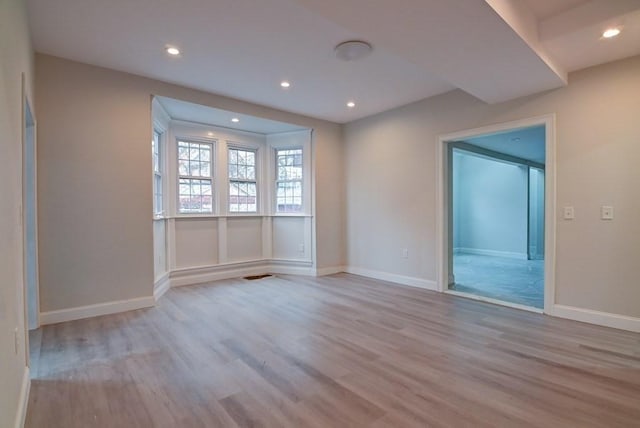 unfurnished room featuring baseboards, recessed lighting, wood finished floors, and visible vents
