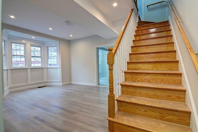 stairway featuring baseboards, recessed lighting, and wood finished floors