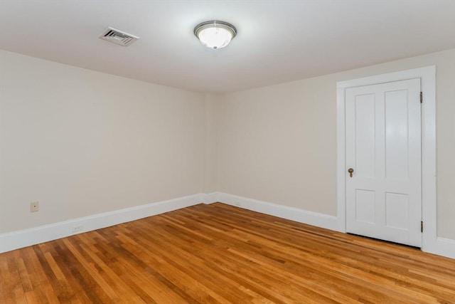 unfurnished room featuring light wood-type flooring, baseboards, and visible vents