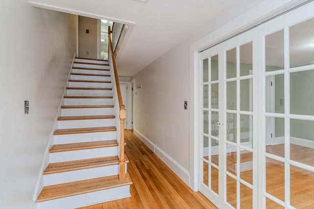 staircase with baseboards and wood finished floors