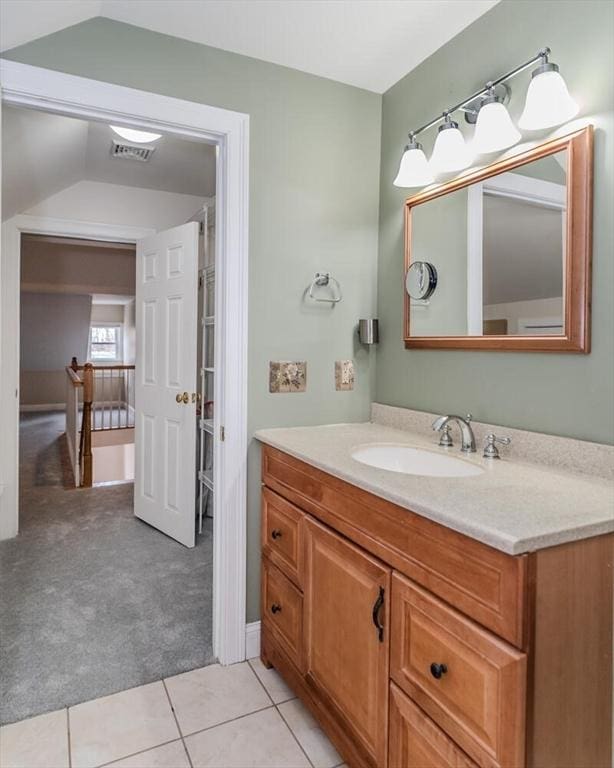 bathroom featuring lofted ceiling, vanity, visible vents, and tile patterned floors